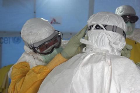 Dr. Joel Montgomery, team leader for the U.S. Centers for Disease Control and Prevention Ebola Response Team in Liberia, is dressed in his personal protective equipment while adjusting a colleague's PPE before entering the Ebola treatment unit in Monrovia, Liberia's capital city