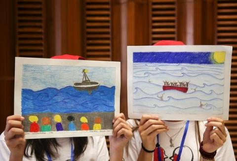 Two girls hold up their drawings about migrants during a meeting with Pope Francis at the Vatican, May 28, 2016. PHOTO BY REUTERS/Alessandro Bianchi