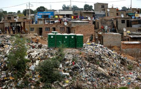 A man stands near public toilets placed on a dump site in Alexandra township, Johannesburg, South Africa, April 10, 2019. PHOTO BY REUTERS/Siphiwe Sibeko