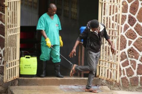 A health worker sprays a visitor with chlorine after leaving the isolation facility, prepared to receive suspected Ebola cases, at the Mbandaka General Hospital, in Mbandaka, Democratic Republic of Congo, May 20, 2018. PHOTOT BY REUTERS/Kenny Katombe