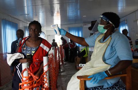 A health worker checks the temperature of a woman as she crosses the Mpondwe border point separating Uganda and the Democratic Republic of Congo as part of the ebola screening at the computerised Mpondwe Health Screening Facility in Mpondwe, Uganda, June 13, 2019. PHOTO BY REUTERS/Newton Nabwaya