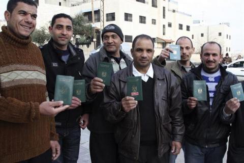 Egyptian men pose with their passports before voting in a referendum on the country's new constitution at the Egyptian embassy in Amman