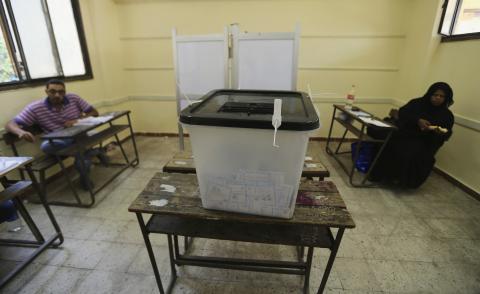 Election officials wait for voters inside a polling station on the second day of voting in the Egyptian election in Cairo