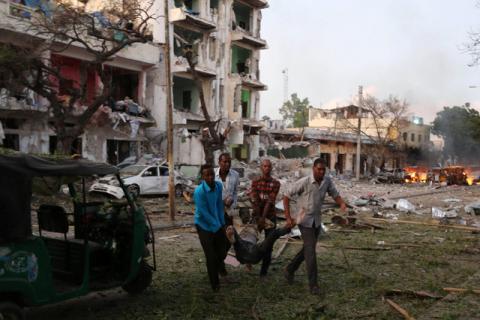 Civilians evacuate an unidentified man injured from the scene of a suicide car bombing outside Hotel Ambassador on Maka Al Mukaram Road in Somalia's capital Mogadishu, June 1, 2016. PHOTO BY REUTERS/Feisal Omar