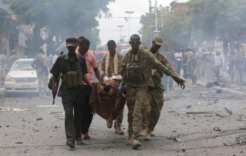 Somali military officers evacuate an injured man from the scene of an explosion in Maka al Mukaram road in Mogadishu, Somalia, July 30, 2017. PHOTO BY REUTERS/Feisal Omar