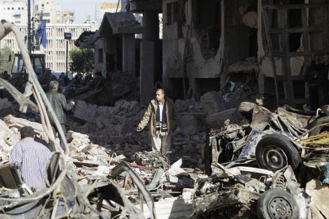 A man walks near debris after an explosion near a security building in Egypt's Nile Delta city of Mansoura in Dakahlyia province, about 120 km (75 miles) northeast of Cairo