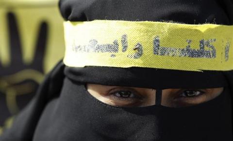 A supporter of the Muslim Brotherhood and ousted Egyptian President Mohamed Mursi, wearing a headband that reads "We all are Rabaa", takes part in a protest against the military and interior ministry