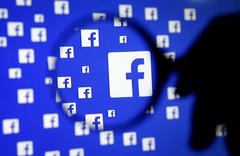 A man poses with a magnifier in front of a Facebook logo on display in this illustration taken in Sarajevo, Bosnia and Herzegovina, December 16, 2015. PHOTO BY REUTERS/Dado Ruvic/Illustration