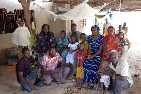 Nfamara Diawarra (C, in gray), 36, poses for a picture with his family in Segoucoura, Senegal, June 18, 2015. PHOTO BY REUTERS/Makini Brice