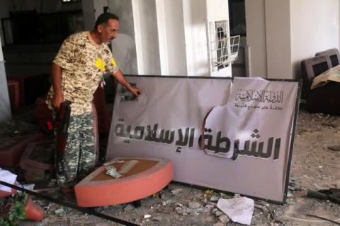 A fighter from Libyan forces allied with the U.N.-backed government displays a sign that reads "Islamic Police" in a building used as a police office by Islamic State militants in neighbourhood Number Three in Sirte, Libya, October 3, 2016. PHOTO BY REUTERS/Hani Amara