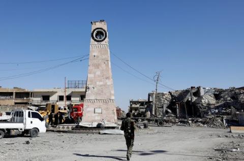 A fighter of Syrian Democratic Forces walks towards a clock tower in Raqqa, Syria, October 18, 2017. PHOTO BY REUTERS/Erik De Castro