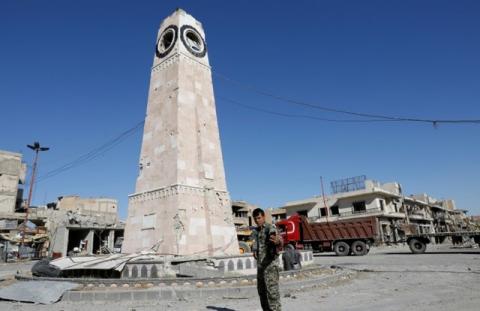 A fighter of Syrian Democratic Forces takes a selfie at a clock tower in Raqqa, Syria, October 18, 2017. PHOTO BY REUTERS/Erik De Castro