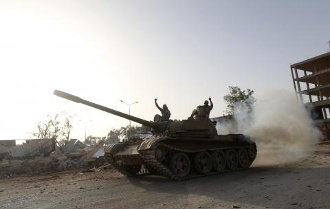 Fighters from the Benghazi Shura Council, which includes former rebels and militants from al Qaeda-linked Ansar al-Sharia, gesture on top of a tank next to the camp of the special forces in Benghazi 