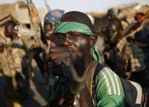 Rebel fighters hold their weapons as they march in a village in the rebel-controlled territory of Upper Nile state