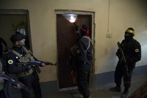 Fighters from the Shi'ite Kata'ib Imam Ali (Imam Ali Brigades) militia search a house after taking control of a village from Islamist State militants, on the outskirts of Dhuluiya, north of Baghdad, December 29, 2014. PHOTO BY REUTERS/Stringer