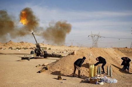 Libya Dawn fighters fire an artillery cannon at IS militants near Sirte, March 19, 2015. PHOTO BY REUTERS/Goran Tomasevic