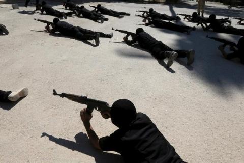 Rebel fighters aim their weapons as they demonstrate their skills during a military display as part of a graduation ceremony at a camp in eastern al-Ghouta, near Damascus, Syria July 11, 2015. PHOTO BY REUTERS/Bassam Khabieh