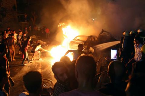 People extinguish a fire from a blast outside the National Cancer Institute, Cairo, Egypt, August 4, 2019. PHOTO BY REUTERS/Shokry Hussien