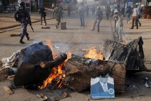 A half burned poster of a opposition candidate is seen at a burned barricade during clashes in Kampala, Uganda, February 15, 2016. PHOTO BY REUTERS/Goran Tomasevic