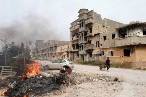 A man pulls a wheelbarrow past destroyed buildings after clashes between military forces loyal to Libya's eastern government and Islamist fighters, in Benghazi, Libya, February 28, 2016. PHOTO BY REUTERS/Esam Omran Al-Fetori