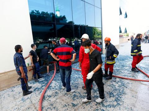 Firefighters and security personnel are seen at the headquarters of Libyan state oil firm National Oil Corporation (NOC) after three masked persons attacked it in Tripoli, Libya, September 10, 2018. PHOTO BY REUTERS/Ismail Zitouny