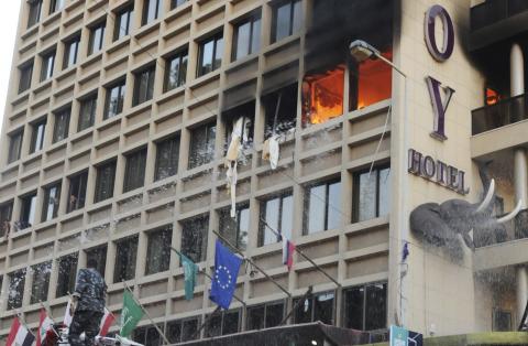 Firefighters put out a fire at Duroy hotel as people watch from windows following a bomb attack, in Raouche, in western Beirut