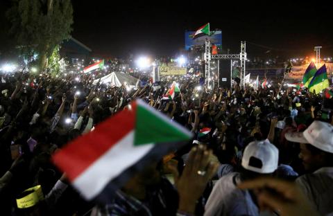 Sudanese demonstrators wave their national flags. PHOTO BY REUTERS/Mohamed Nureldin Abdallah