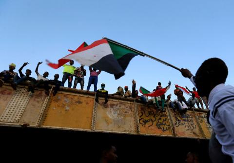 A Sudanese demonstrator from the Darfur region waves a Sudanese national flag from atop a bus as he arrives to be part of a mass anti-government protest outside Defence Ministry in Khartoum, Sudan, April 30, 2019. PHOTO BY REUTERS/Mohamed Nureldin Abdallah