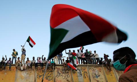 Sudanese protester waves flags during a demonstration in front of the defense ministry compound in Khartoum, Sudan, May 2, 2019. PHOTO BY REUTERS/Mohamed Nureldin Abdallah