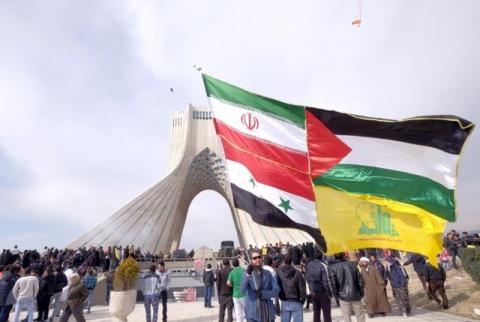 A man carries a giant flag made of flags of Iran, Palestine, Syria and Hezbollah, during a ceremony marking the 37th anniversary of the Islamic Revolution, in Tehran, February 11, 2016. PHOTO BY REUTERS/Raheb Homavandi/TIMA