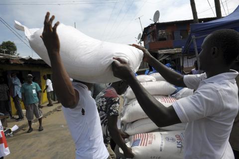 A resident of West Point neighbourhood, which has been quarantined following an outbreak of Ebola, receives food rations from the United Nations World Food Programme (WFP) in Monrovia