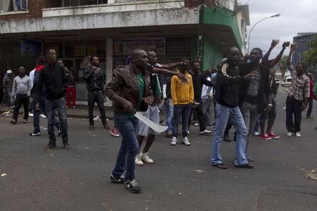 A group of foreign nationals threaten to defend themselves as police get between them and South Africans after a peace march in Durban, April 16, 2015. At least four people have been killed in a wave of anti-immigrant violence that started two weeks ago in Durban. PHOTO BY REUTERS/Rogan Ward