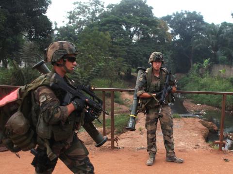 French soldiers take positions along a road during a daytime patrol in Bangui, where shooting continued overnight in the neighbourhoods around the capital