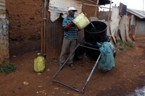 A Kenyan 'frogger' slum dweller Patrick Osunda uses a broken plastic jerrycan to load excrement from a pit latrine into a metallic barrel in Kibera slum within Nairobi, Kenya, February 24, 2019. PHOTO BY REUTERS/Njeri Mwangi