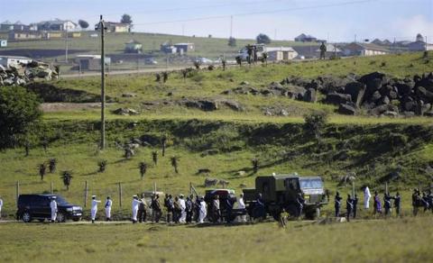 The coffin of former South African President Nelson Mandela is escorted as it arrives for the funeral ceremony in Qunu