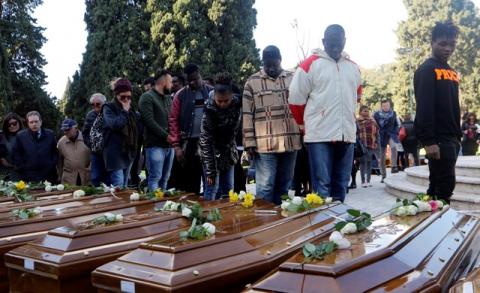 People pay respect as they walk by the coffins ahead of the funeral service for 26 Nigerian women who died last week while crossing the Mediterranean Sea, at the Salerno cemetery, Italy, November 17, 2017. PHOTO BY REUTERS/Ciro De Luca