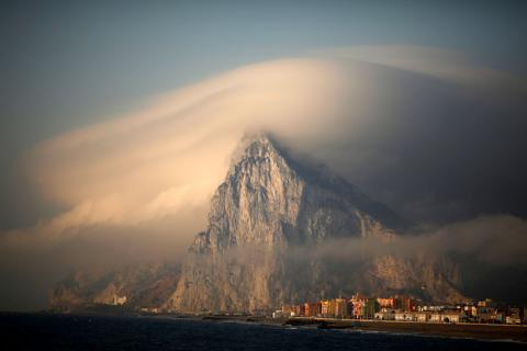 A cloud partially covers the tip of the Rock of the British territory of Gibraltar at sunrise from La Atunara port before Spanish fishermen sail in their fishing boats with their relatives to take part in a protest at an area of the sea where an artificial reef was built by Gibraltar using concrete blocks, in Algeciras bay, La Linea de la Concepcion in southern Spain, August 18, 2013. PHOTO BY REUTERS/Jon Nazca