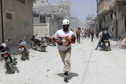 A civil defence member carries an injured girl at a site hit by airstrikes in the rebel-controlled area of Maaret al-Numan town in Idlib province, Syria, June 2, 2016. PHOTO BY REUTERS/Khalil Ashawi