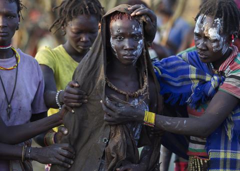 A Pokot girl, covered in animal skins, walks to a place where she will rest after being circumcised in a tribal ritual in a village about 80 kilometres from the town of Marigat in Baringo County, Kenya, October 16, 2014. PHOTO BY REUTERS/Siegfried Modola