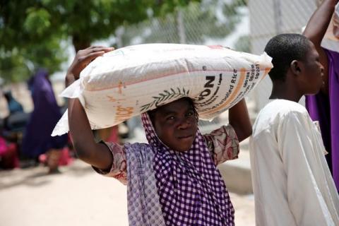 A woman carries a bag of rice during a food rationing at an internally displaced persons (IDP) camp on the outskirts of Maiduguri, northeast Nigeria, June 6, 2017. PHOTO BY REUTERS/Akintunde Akinleye