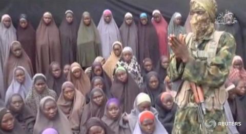 A still image from a video posted by Nigerian Islamist militant group Boko Haram on social media, seen by Reuters on August 14, 2016, shows a masked man talking to dozens of girls the group said are school girls kidnapped in the town of Chibok in 2014. PHOTO BY REUTERS/Social Media