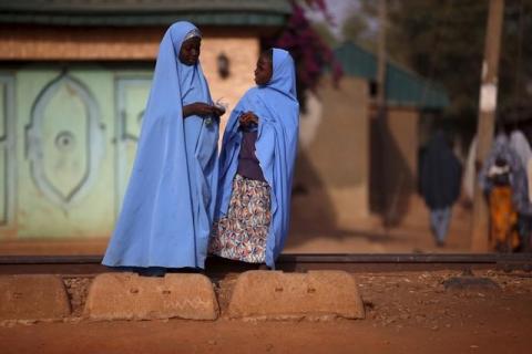 Two girls chat to each other while standing near the railway line in Kaduna state, Nigeria, February 2, 2016. PHOTO BY REUTERS/Afolabi Sotunde