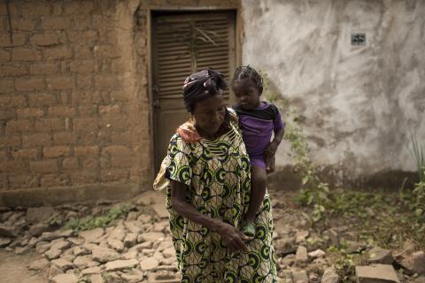 Warache Anne Marie carries her granddaughter Lairssa, as they flee from their home due to the continuing sectarian violence in the district of Miskine, in the capital Bangui