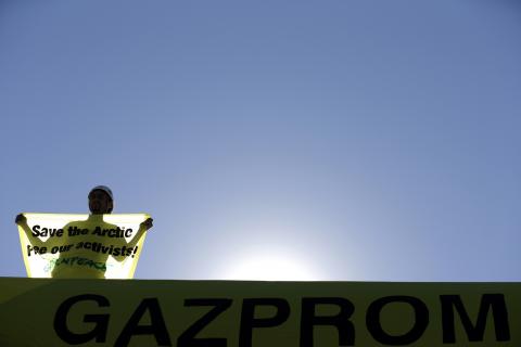 A Greenpeace activist stands on top of the roof of a Gazprom gas station near the city of Blagoevgrad, some 100 km (62 miles) south of Sofia