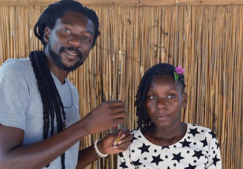 Cadino Chipanga puts the finishing touches on a customer's dreadlocks at his salon in Mafalala, on the outskirts of Maputo, Mozambique, February 13, 2020. PHOTO BY REUTERS/Grant Lee Neuenburg