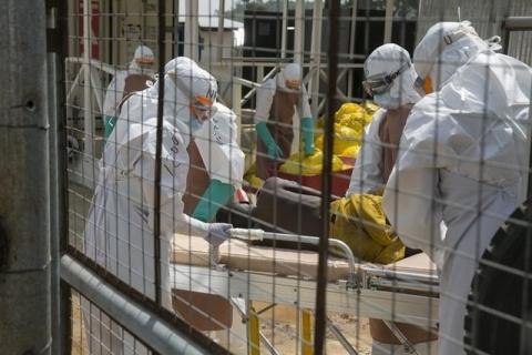 British health workers lift a newly admitted Ebola patient onto a wheeled stretcher in to the Kerry town Ebola treatment centre outside Freetown, December 22, 2014. PHOTO BY REUTERS/Baz Ratner