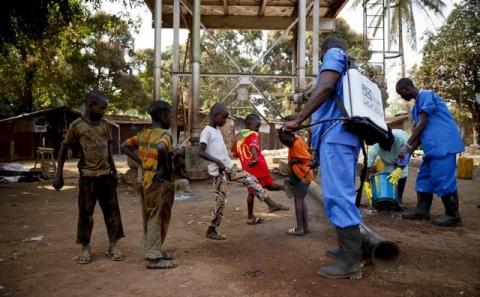 Children come forward to get their feet disinfected after a Red Cross worker explained that they are spraying bleach, and not spraying the village with the Ebola virus, in Forecariah, January 30, 2015. PHOTO BY  REUTERS/Misha Hussain