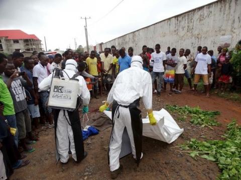 Healthcare workers prepare to remove the body of a man suspected of carrying Ebola in Monrovia, Liberia, July 17, 2015. PHOTO BY REUTERS/James Giahyue