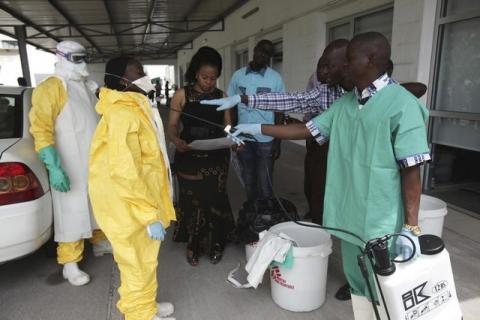 A health worker sprays a colleague with disinfectant during a training session for Congolese health workers to deal with Ebola virus in Kinshasa, October 21, 2014. PHOTO BY REUTERS/Media Coulibaly