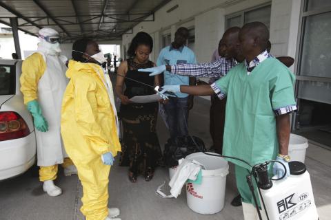 A health worker sprays a colleague with disinfectant during a training session for Congolese health workers to deal with Ebola virus in Kinshasa October 21, 2014. PHOTO BY REUTERS/Media Coulibaly